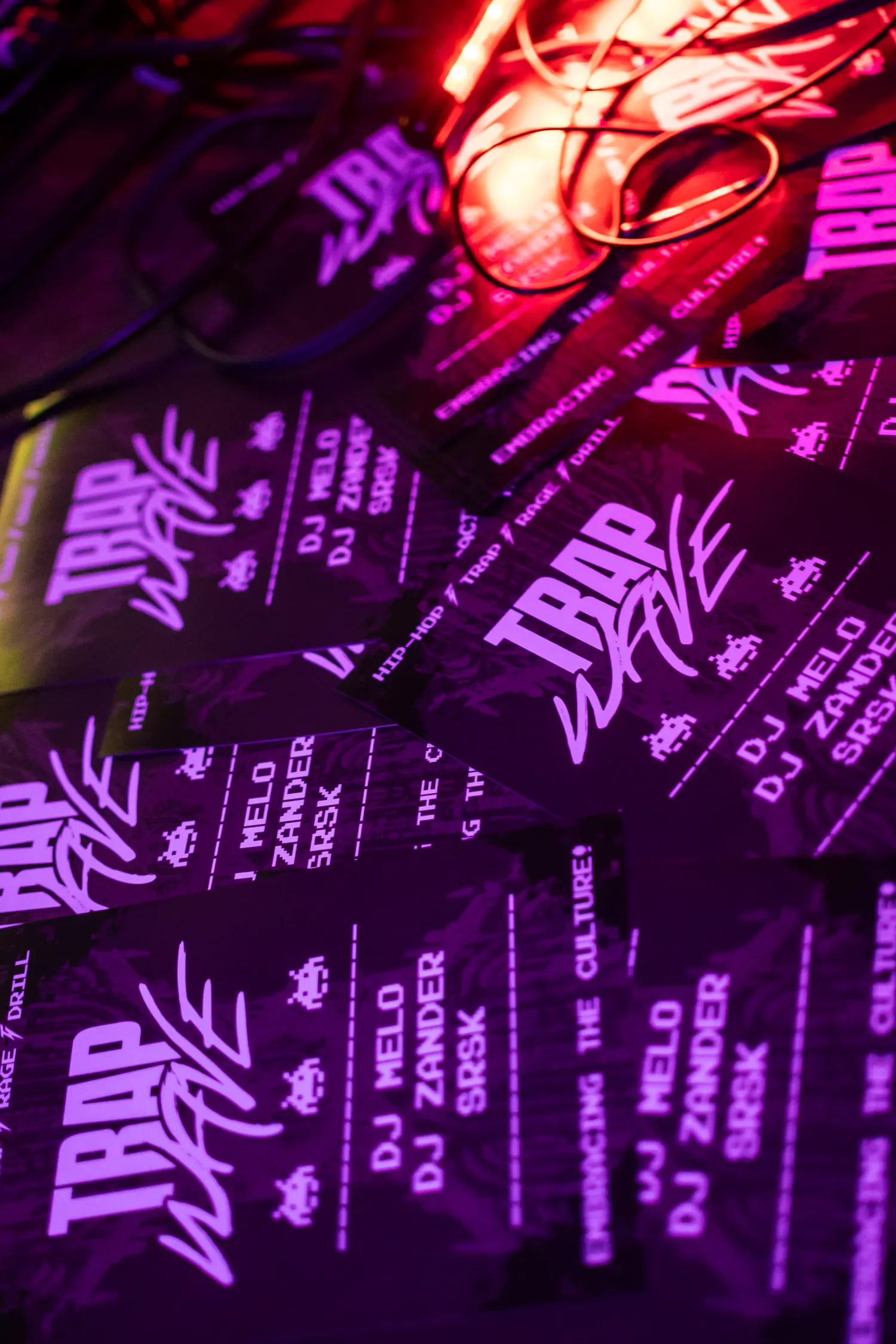 A scattered pile of the printed flyers under red and purple light.