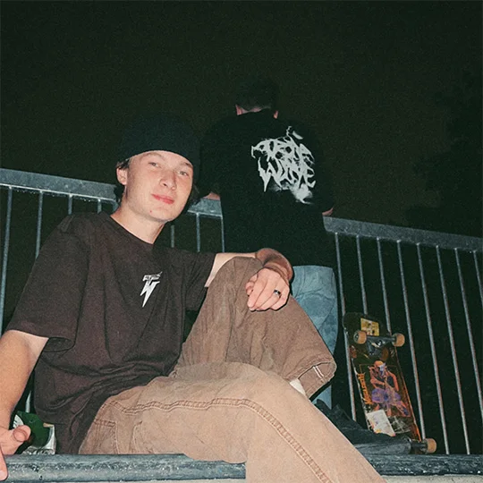 Two people in the black Halloween tee, one showing the chest bolt and one the back print.