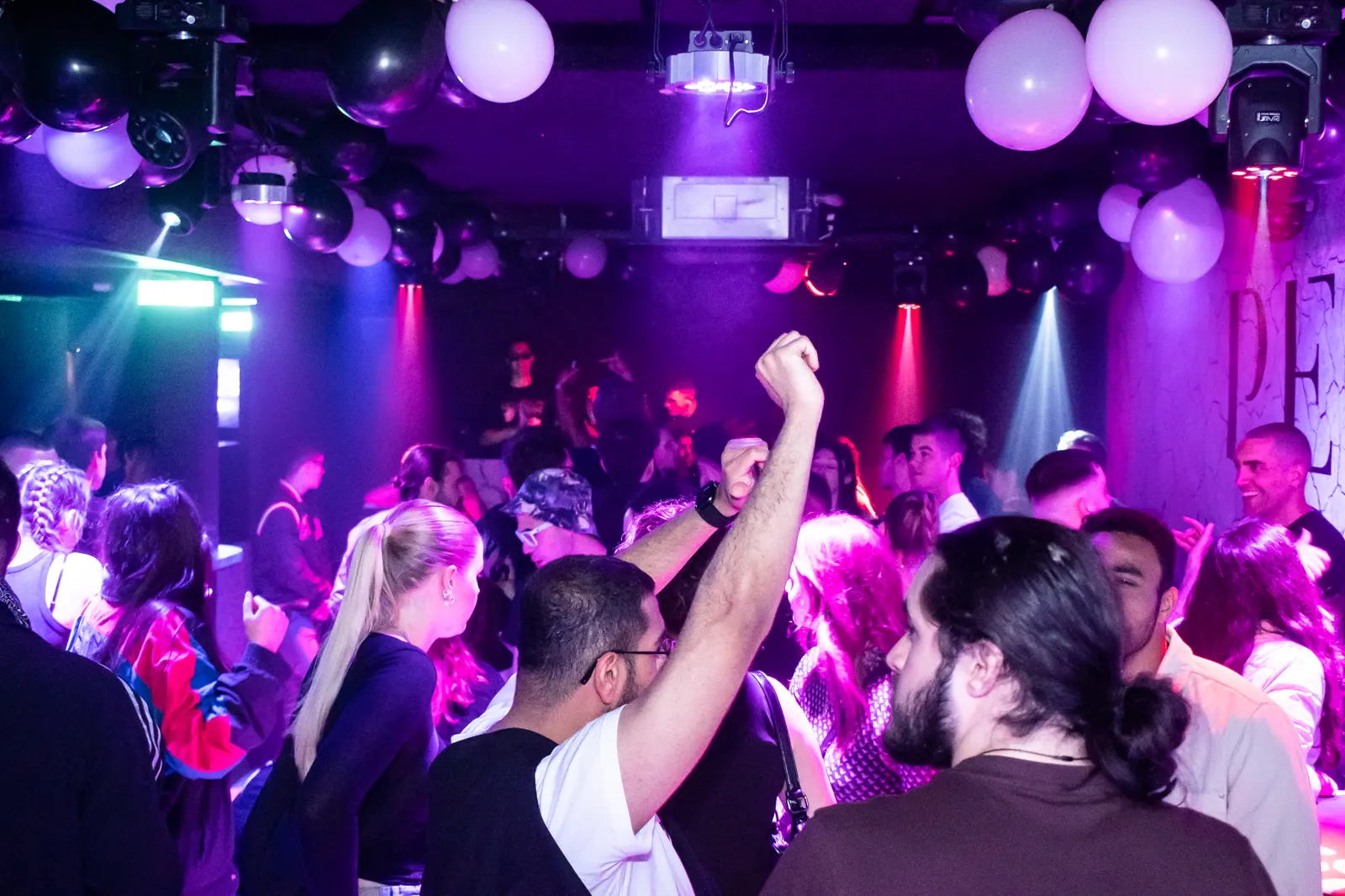 The same room in purple, a raised fist in the middle of the crowd.